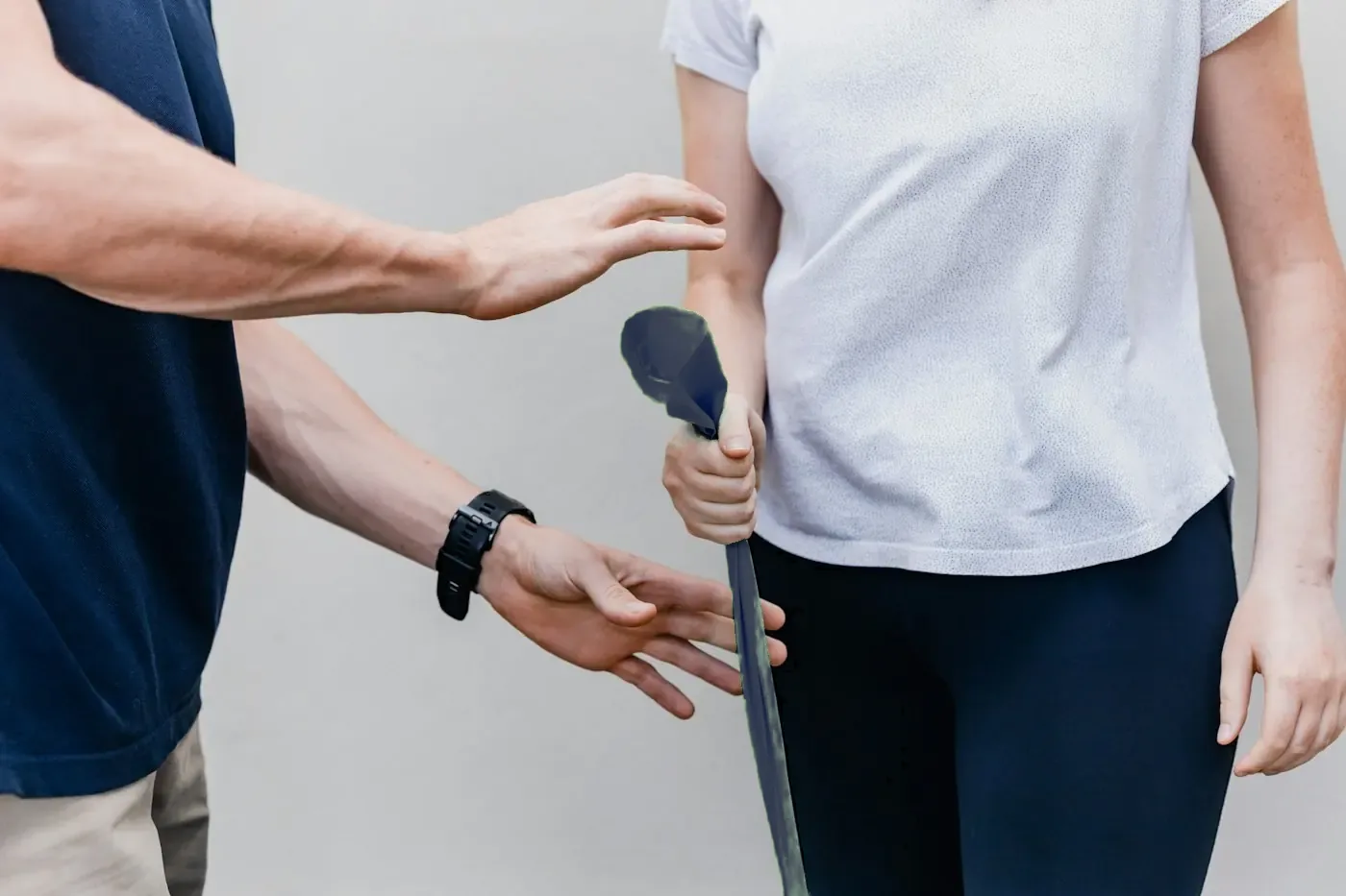 Ein Therapeut zeigt einer Patientin, wie sie das Übungsband für das Heimprogramm hält.